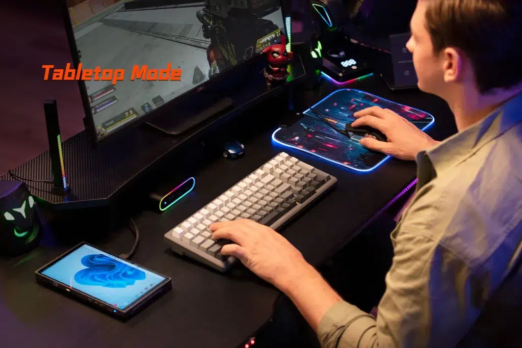 gempages5227571092389898438c2647f78344424b867020d83a53b2f8 DROIX Global A user playing a first person shooter on an external monitor connected to the ONEXPLAYER X1 Mini showcasing its Tabletop Mode functionality for desktop like gaming with a keyboard and mouse