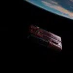 Rendered scene of the AYANEO AG01 floating in space above Earth emphasizing its Starship theme and sci fi design aesthetic